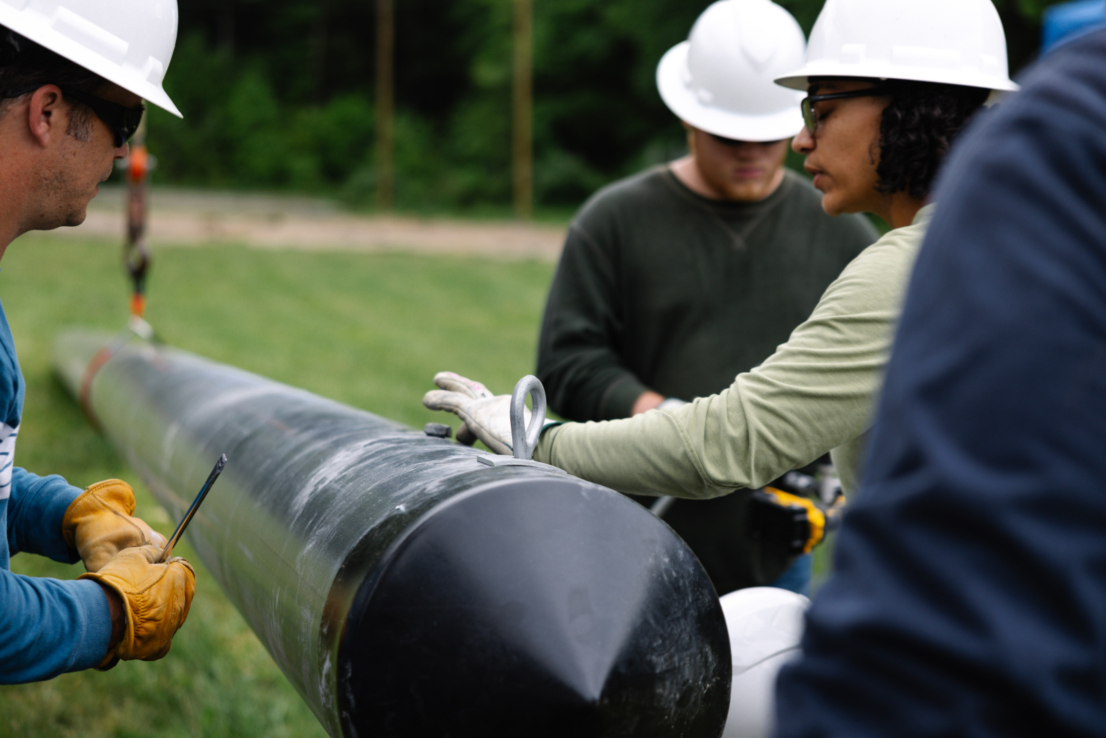 Electrical line workers installing composite pole